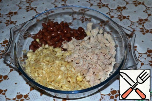 In a deep bowl, put the cabbage, canned red beans and chicken boiled meat, cut into cubes.