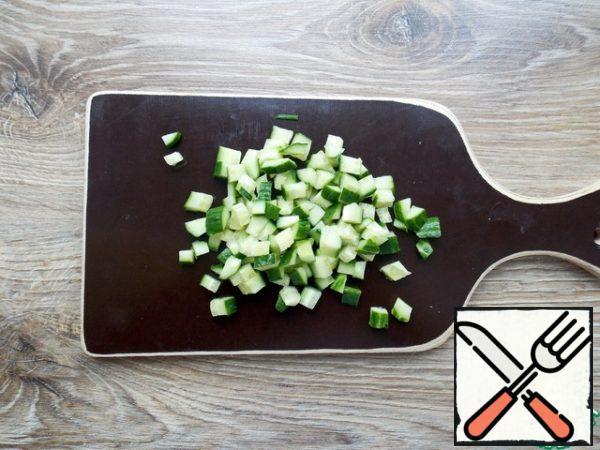 Wash the cucumber and cut it into cubes, add it to the tuna.