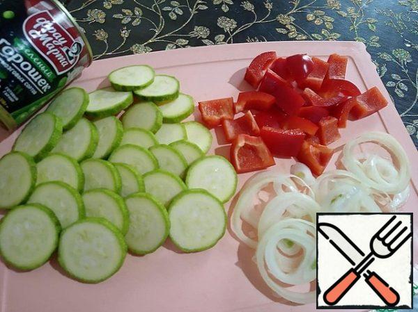 Peel the onion and cut into rings. Cut the zucchini into thin slices, wash and dry. Peppers are peeled from seeds and cut into large pieces.