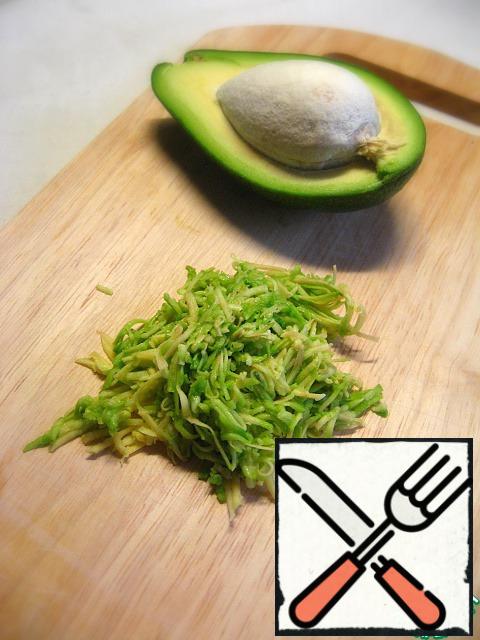 Peel the avocado, separate the bone, and grate the flesh on a fine grater.