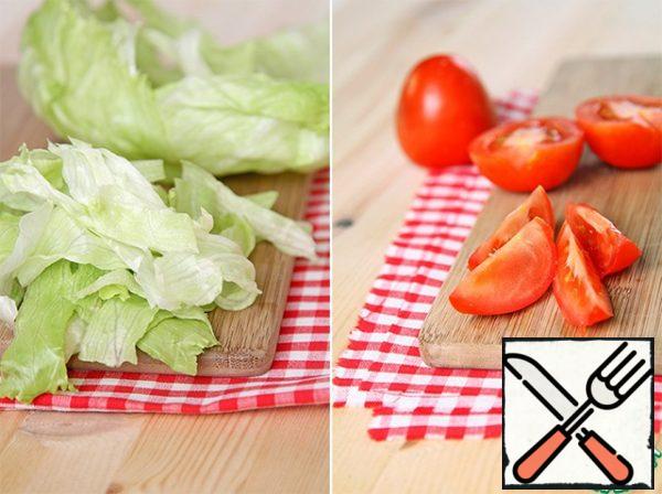 Tear the salad or cut it into small pieces, leaving several layers to serve on the table.
Cut the tomatoes into slices.