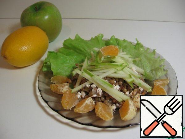 Since the salad turns out to be somewhat indeterminate, we will put fruit on top.
We clean the tangerines, disassemble them into slices, cut each in half. Cut the apple into thin strips and immediately put it in a bowl with lemon juice diluted with water (I can't understand how everyone is "sprinkled" with lemon juice, which does not darken anything for anyone).
Arrange the salad on plates, decorate with fruit on top. I did it like this.