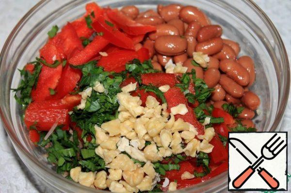 Add the cold beans to the salad. Then add the chopped nuts that are not quite fine, having previously peeled them ( to easily peel the nuts, fill with hot water and the skin is easy to clean).