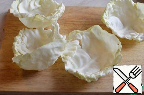 Separate 4 leaves from the cabbage and pour boiling water over them.
