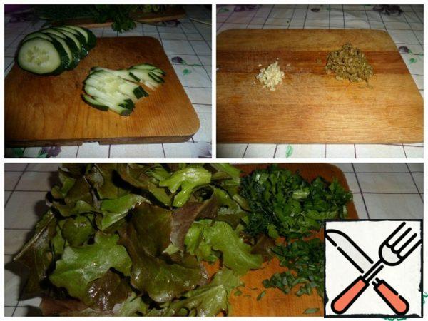 Cut cucumbers into strips, chop garlic, finely chop herbs and olives. Slice the lettuce leaves with your hands.