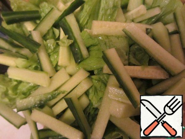 Let's tear the salad into small pieces with our hands. Cucumbers cut into cubes.