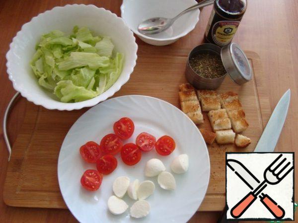 Lettuce leaves are well washed and dried with a paper towel. We tear salad leaves with our hands. Spread in a salad bowl.
Cut the mozzarella and cherry in half.
Dry the bread in a toaster. If there is no toaster , you can dry the bread in a dry pan.
Cut a piece of dried bread into small cubes.