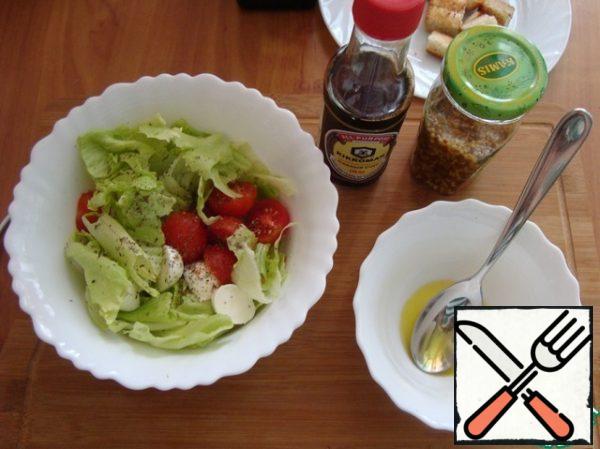 Cherry tomatoes and mozzarella spread in a salad bowl with lettuce leaves. Sprinkle with Provencal herbs. I added a pinch of seasoning.
Make the dressing for the salad. Pour olive oil into a Cup.