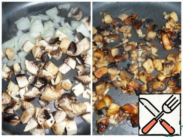 Pour 2 tablespoons of vegetable oil into a frying pan, put the onion and mushrooms. Fry until soft.
