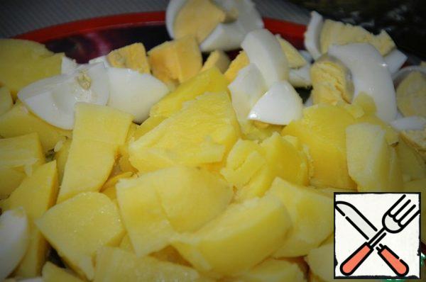 Boiled potatoes cut warm, large cubes, eggs are also large.