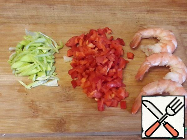 Cut off a small part of the shrimp , leaving the tails. Cut the cut part into small pieces .