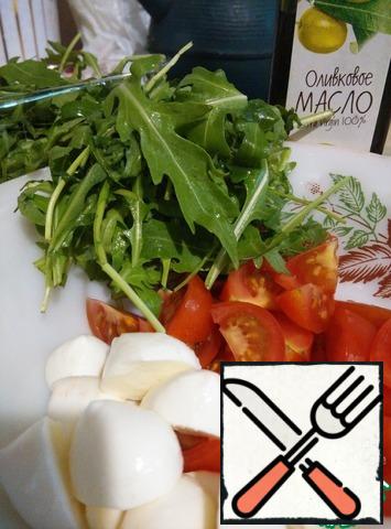 Wash the cherry tomatoes and cut them into 4-6 pieces. Cut the mozzarella balls in half. Wash and dry the arugula.
