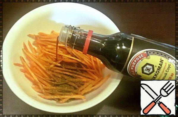 Add ground coriander, black pepper and soy sauce (cooked in a natural way) to a container with carrots.
