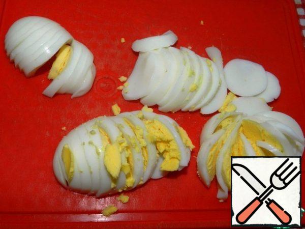 Cook the eggs and cut them into slices. Leave some of the slices for decoration.