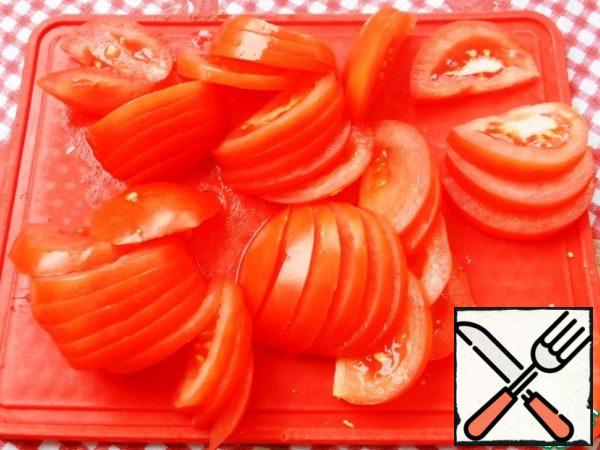 Cut the tomatoes into slices. Leave some of the slices for decoration.