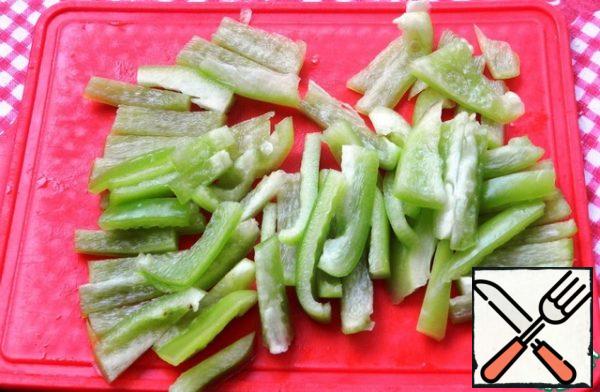 Peel the peppers and cut them into strips.