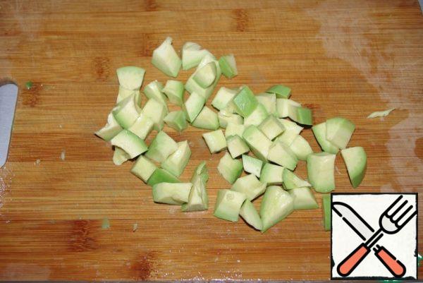Wash the avocado, peel it and cut it into cubes.