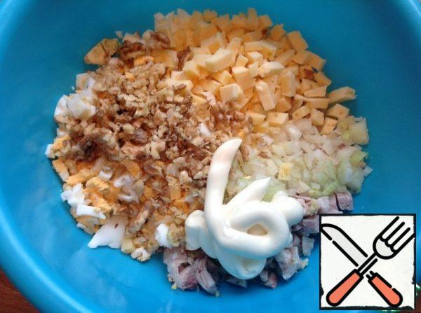 Cheese 70 gr cut into a small cube, add mayonnaise and chopped nuts, but not quite in the crumbs. Mix the salad.