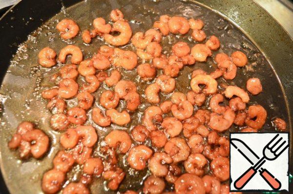 Then pour in the pomegranate sauce and fry the prawns until they have a caramel sheen. Immediately transfer the prawns from the pan to a bowl to stop the cooking process.