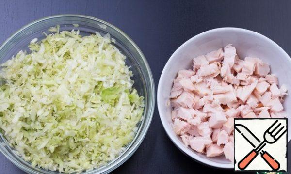 Cabbage is better to choose fresh, juicy, then you will have to add less mayonnaise. Grate the cabbage on a large grater. Cut the chicken breast into medium cubes.