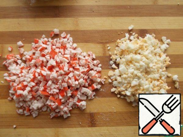 Finely chop the egg and crab sticks.