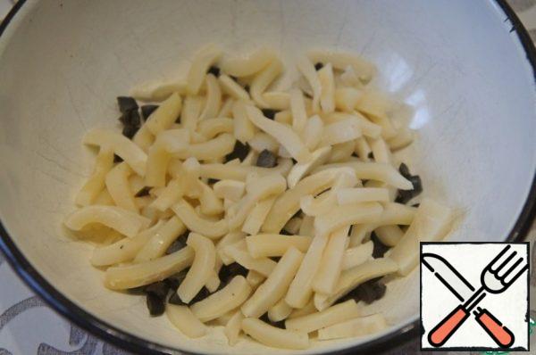 Cut the olives into half-rings, and the squid fillets into strips or straws.