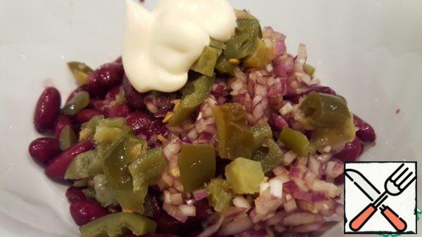 Open a jar of red beans and drain the liquid. Put the beans, chopped jalapeno and onion in a salad bowl along with soy sauce. Add mayonnaise and stir. If there is a reserve of time, it is better to let the salad brew a little.