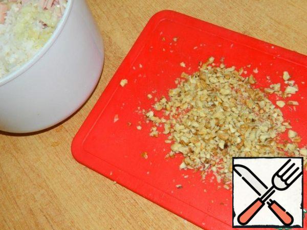 Chop the walnuts . Mix everything, season with mayonnaise and mix well.