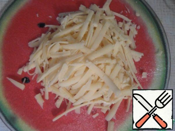 Grate the cheese on a coarse grater.