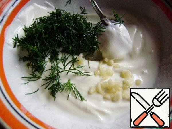 Prepare the dressing. Finely chop the dill, squeeze the garlic into a garlic press and add to the sour cream. Add salt to taste.