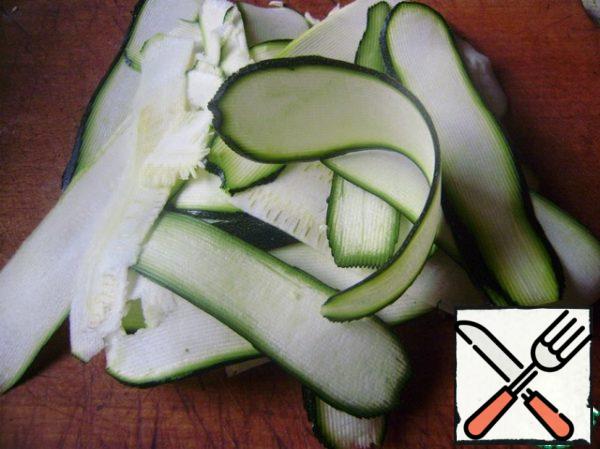 Zucchini cut into thin slices using a vegetable peeler.
