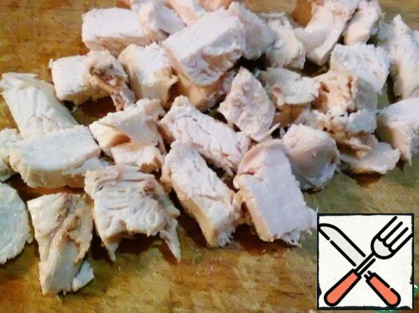 Boil the chicken fillet and cut it into not very small cubes. About 1 cm side.