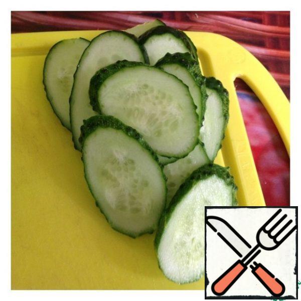Cucumbers cut into circles or obliquely.
When serving: put the cucumber mugs on a plate, and put the salad in the center. By the way, a more tender and juicy salad will be if cucumbers are cut into thin strips or grated on a grater for Korean carrots, and immediately added to the salad.