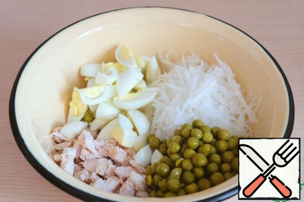 Combine the chopped chicken fillet and eggs, grated radish, and canned peas in a bowl .