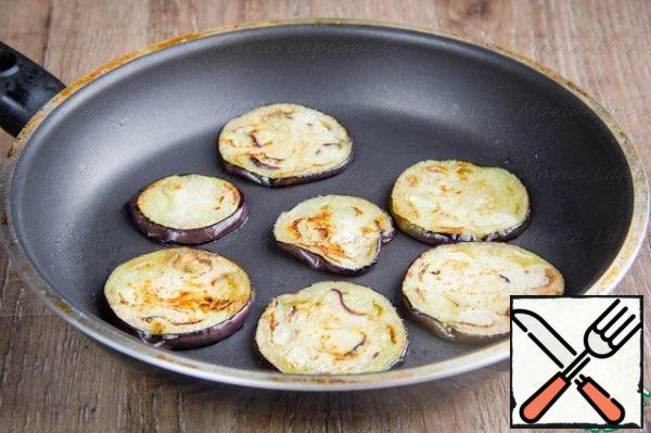 Cut the eggplant into slices, add salt and leave on a paper towel for 5-10 minutes . Then blot the protruding moisture and fry the eggplant until cooked in vegetable oil.