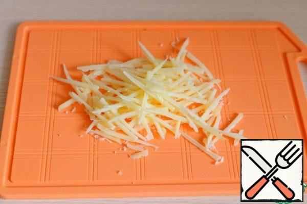 Grate the cheese on a small grater.