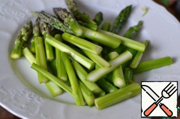 Cut the asparagus in half.
