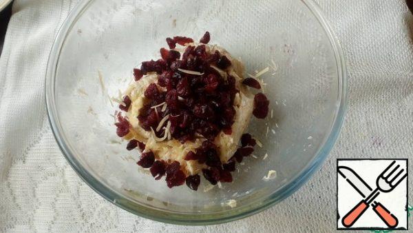 Grate the hard cheese on a fine grater. Add cream cheese and sauce. Stir.
Add the cranberries. Stir.