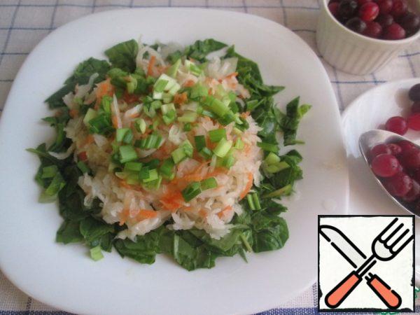 Put the chopped spinach on a platter, and sauerkraut on it. Season with vegetable oil (1-2 tbsp. l.) and add finely chopped green onions.