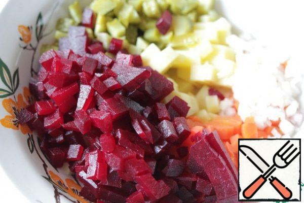 Peel the potatoes, beets, carrots and onions and cut them into small cubes.
Just cut the pickles.