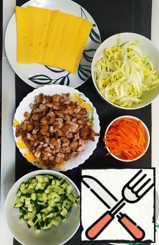 Then prepare the filling and arrange on plates: cut tomatoes and cucumbers into cubes, chop the cabbage, cut the cheese into slices, arrange the chicken fillet and carrot in Korean.