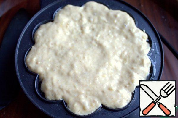 Transfer a few spoonfuls of dough to the waffle iron and quickly smooth it out. Cover and fry.