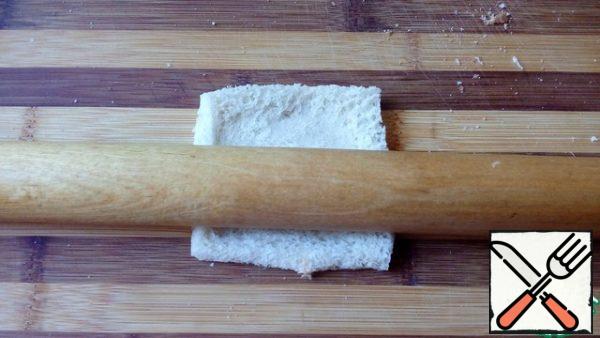 Cut the crust off the toast bread and roll out each piece with a rolling pin.