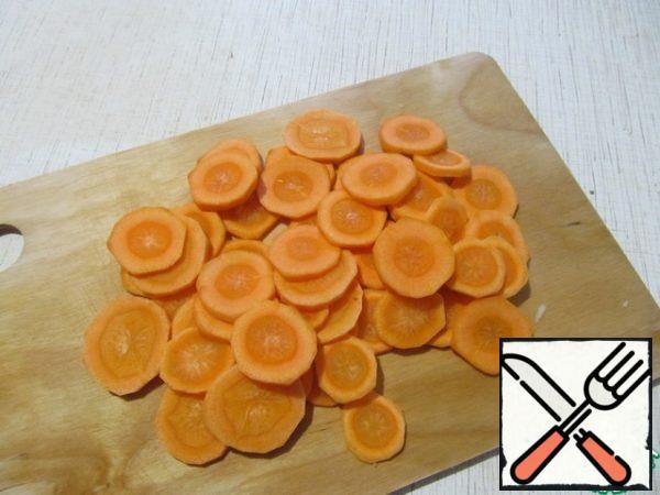Peel the carrots and cut them into thin slices.