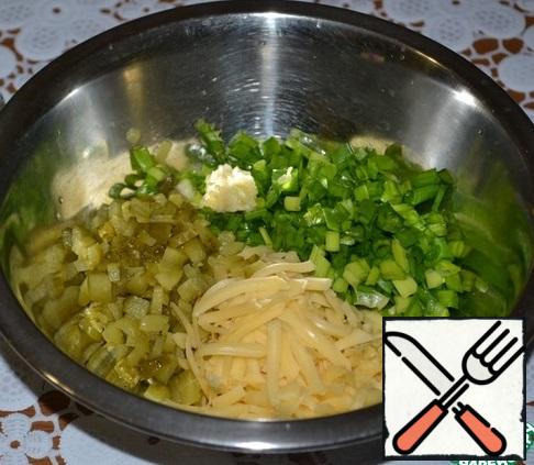 Grate the cheese on a large grater, cut the green onions. Add the gherkins and squeezed garlic.