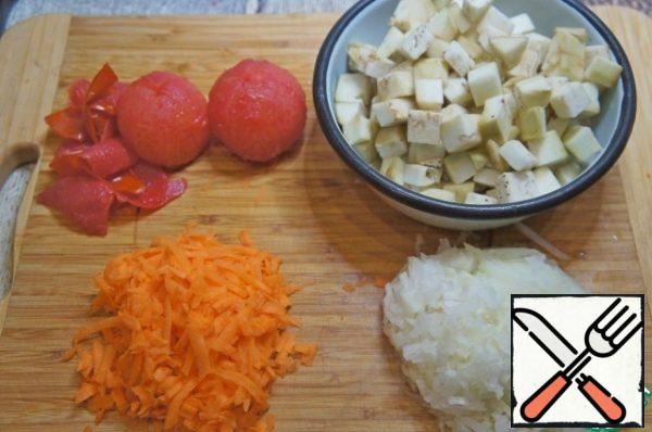 Peel the carrots and grate them on a large grater. Chop the onion at random. Peel the eggplant and cut it into cubes. Blanch the tomatoes and peel them.