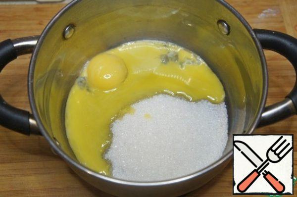 First, prepare the cream, it is better to do it in the evening.
Put the yolks and sugar in a saucepan and mix with a whisk.