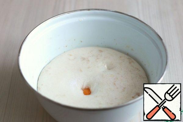 After a certain time, a lush cap of small bubbles forms on the surface. The dough is ready.
Then add 1 teaspoon of salt, 2 egg yolks and 1 tablespoon of vegetable oil. Whisk the mixture with a fork.