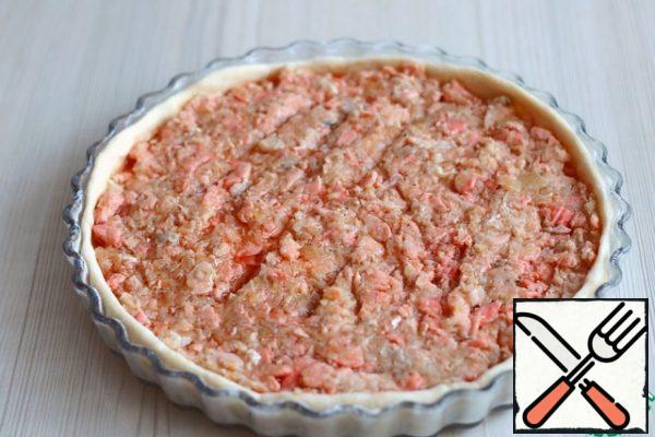 Divide the dough into 2 parts, roll out in layers of thickness 0,5-0,7 see a Layer of dough to transfer to a baking pan pie. Pre-form grease with a thin layer of butter , sprinkle with flour, make a "French shirt".
Put the prepared minced fish on the dough layer.