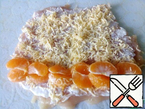 Grate the cheese and sprinkle it on top. Disassemble the tangerines into slices and spread out on the edge.